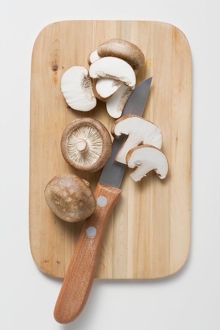Shiitake mushrooms with knife on chopping board