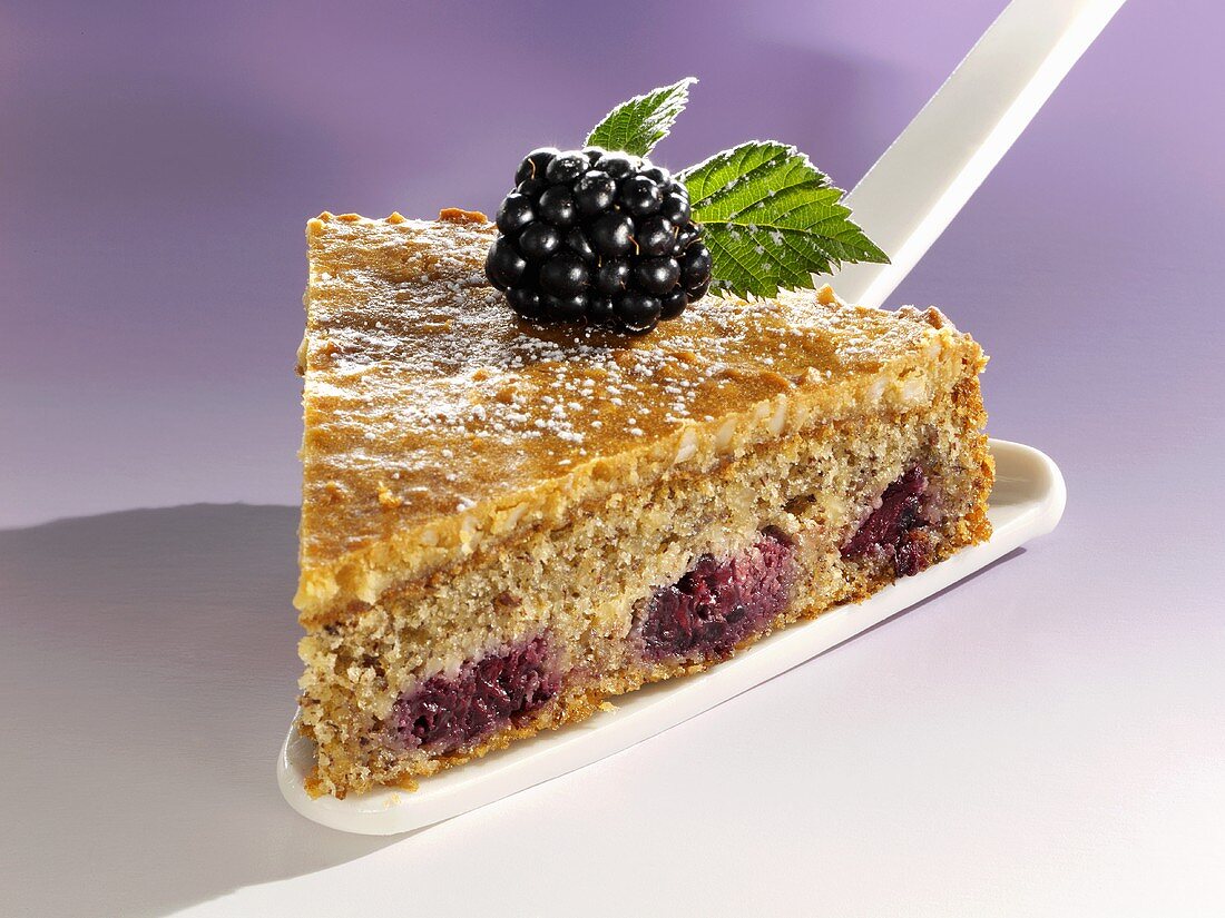 A piece of blackberry nut cake on cake server