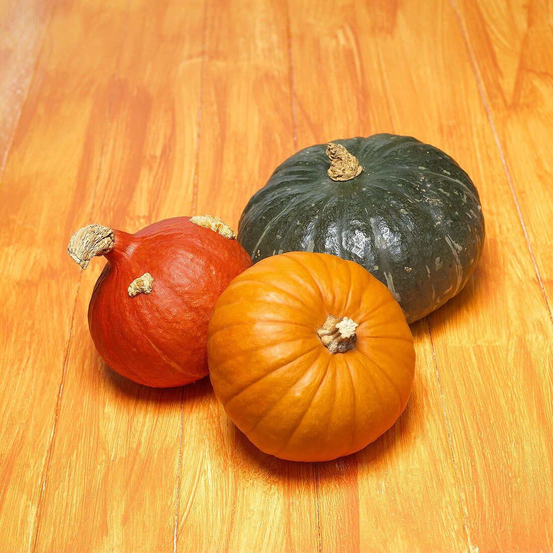 Three pumpkins on orange background