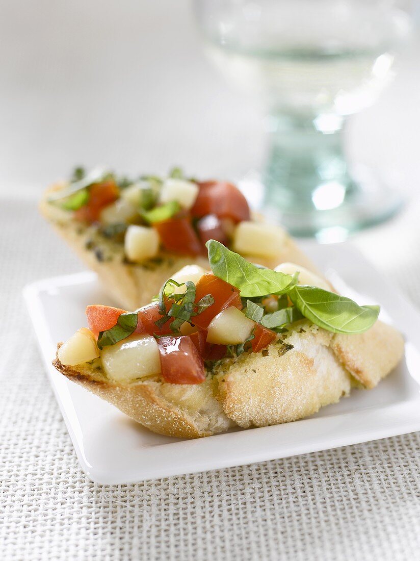 Baguette slices topped with tomato and smoked mozzarella