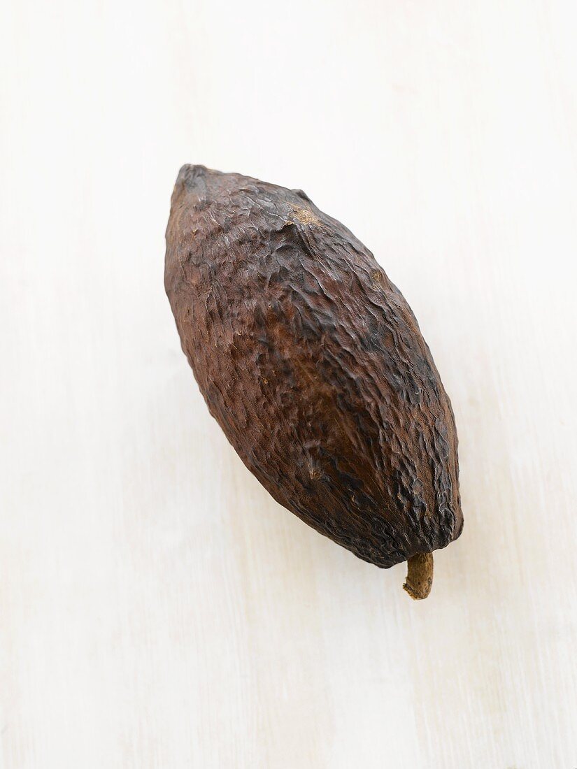 Eine Kakaofrucht auf weisser Holzplatte