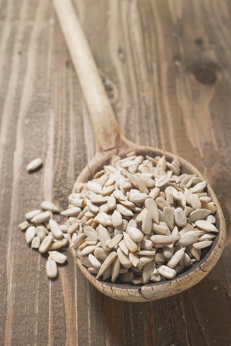 Shelled sunflower seeds on wooden spoon