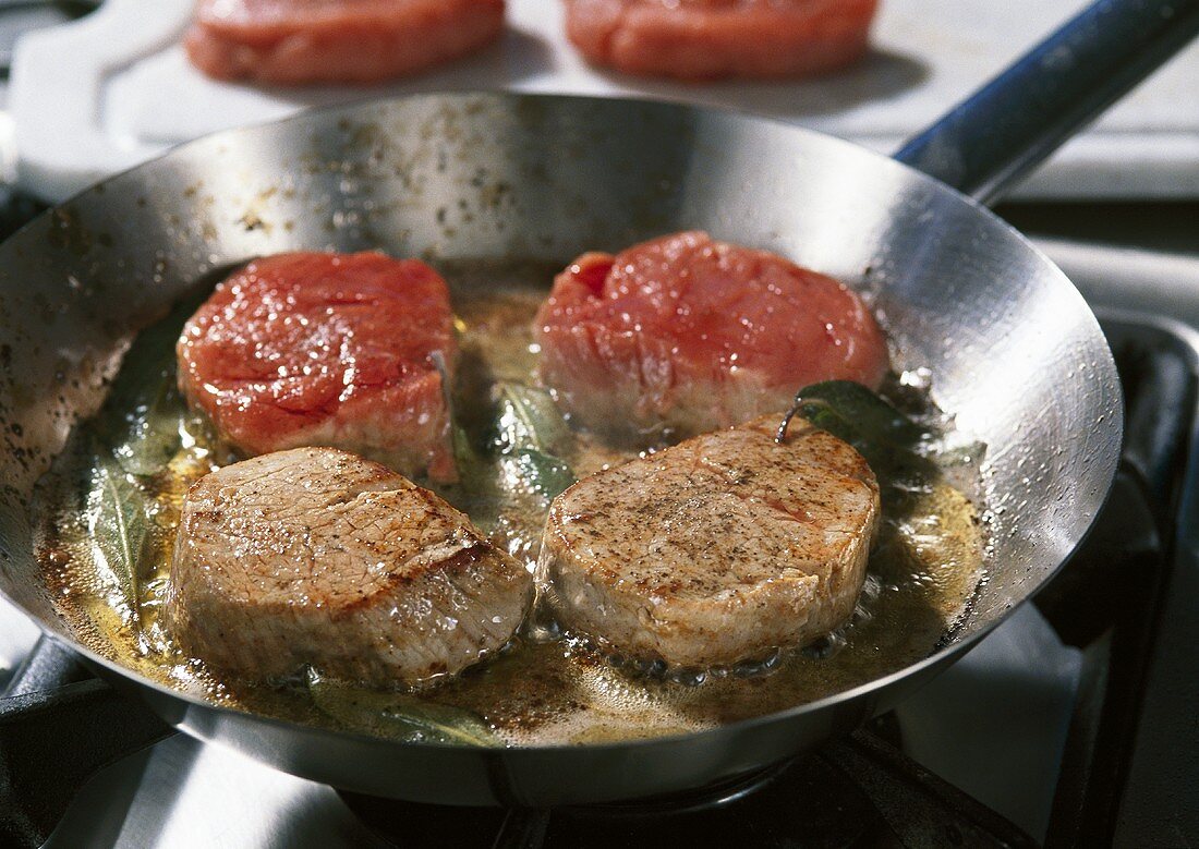 Frying veal medallions in a frying pan
