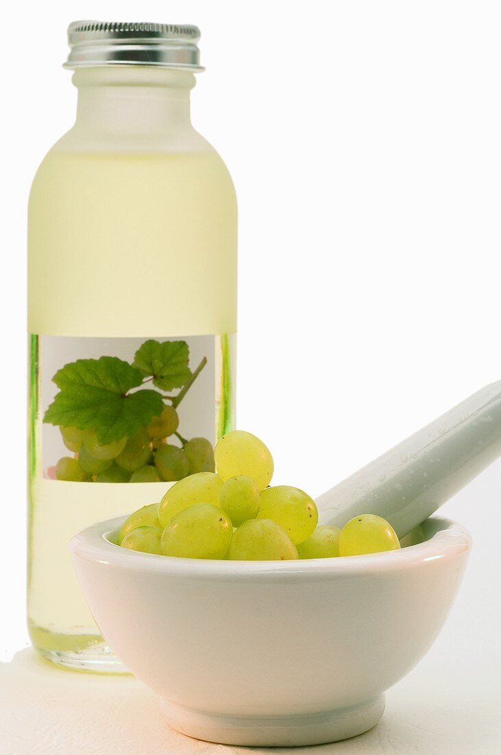 weiße Weintrauben im Mörser und weisses Traubenkernöl