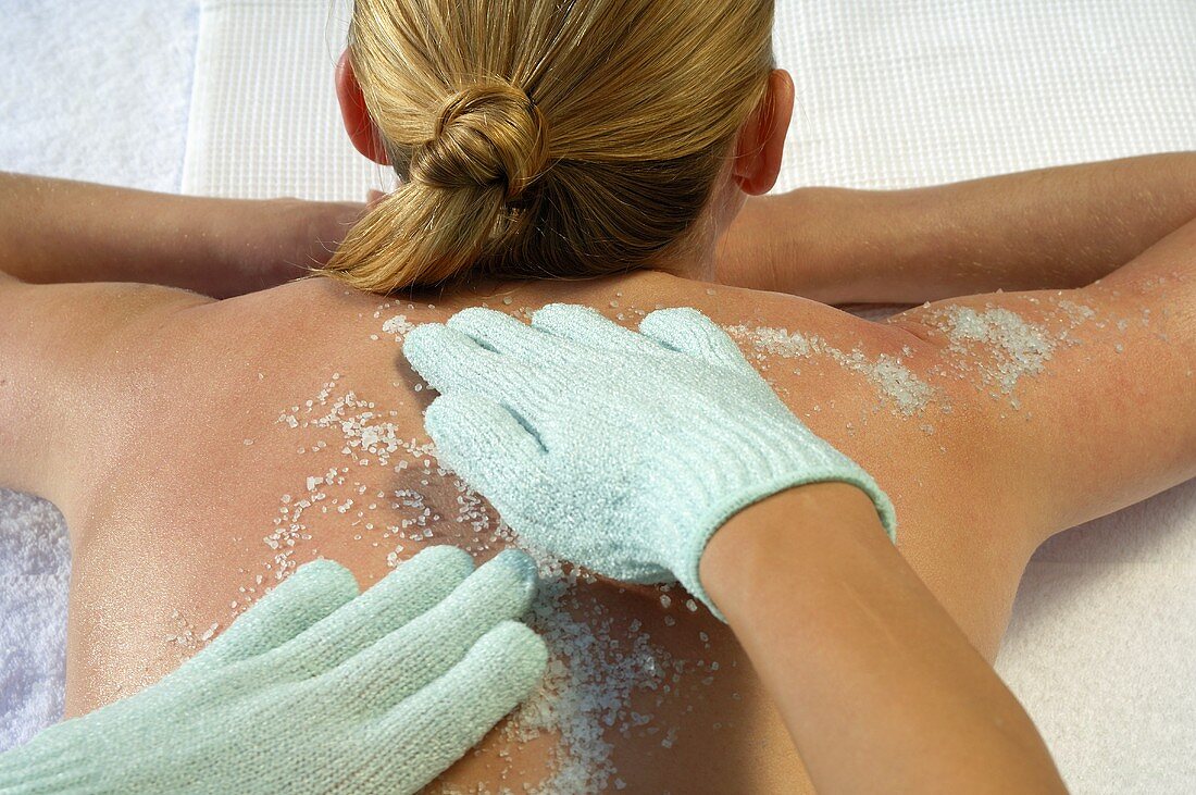 Hands applying exfoliating scrub