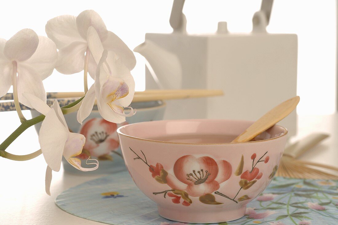 Asian tea in tea bowl and orchids