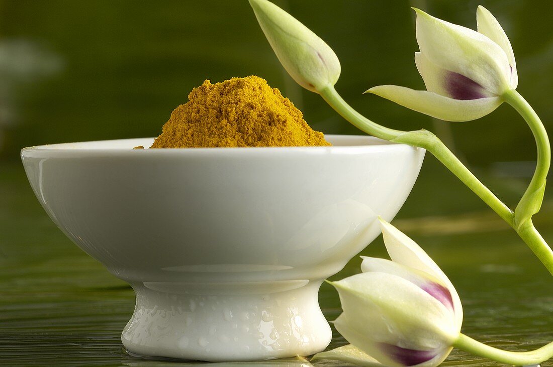 Bowl of turmeric and orchid