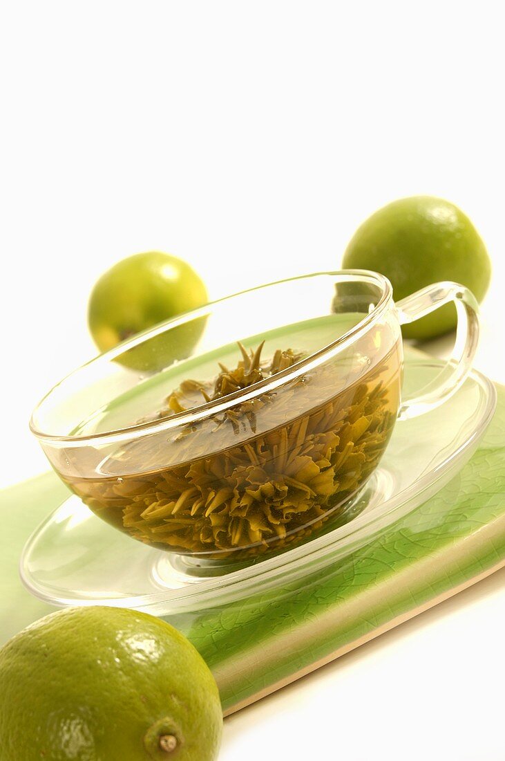 A cup of green tea with limes