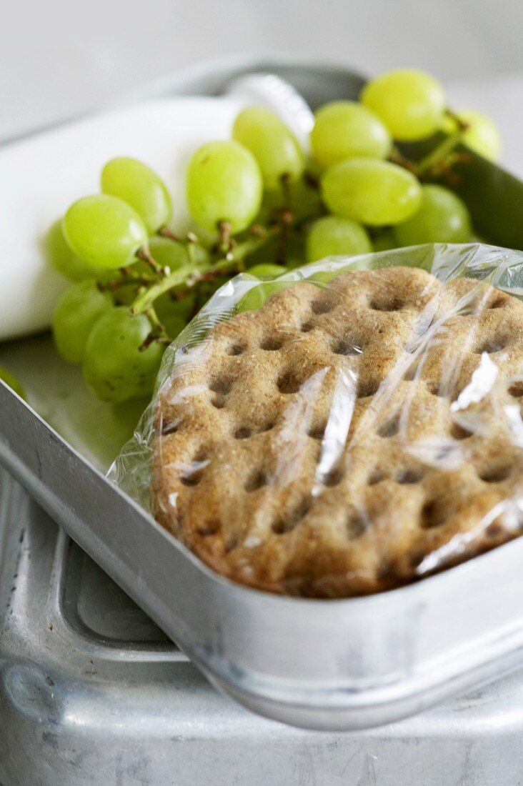 Lunchbox mit Knäckebrot-Sandwich und grünen Trauben