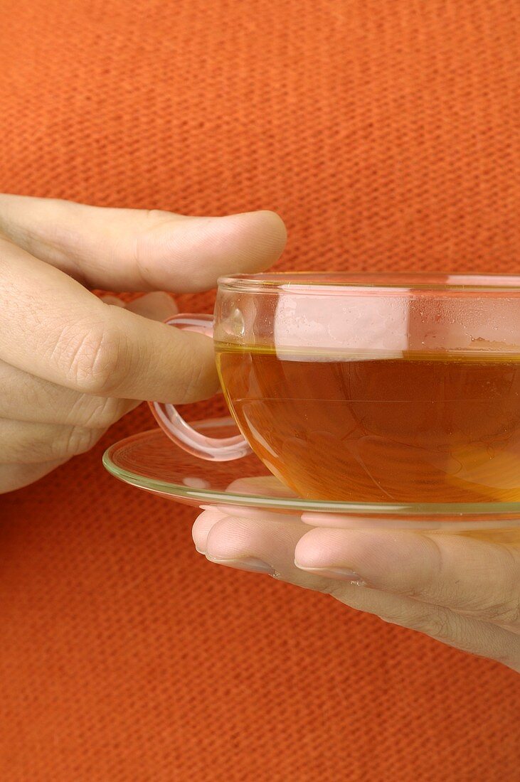 Hand holding a cup of St. John's wort tea