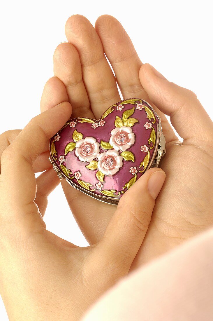 Hands holding heart-shaped box