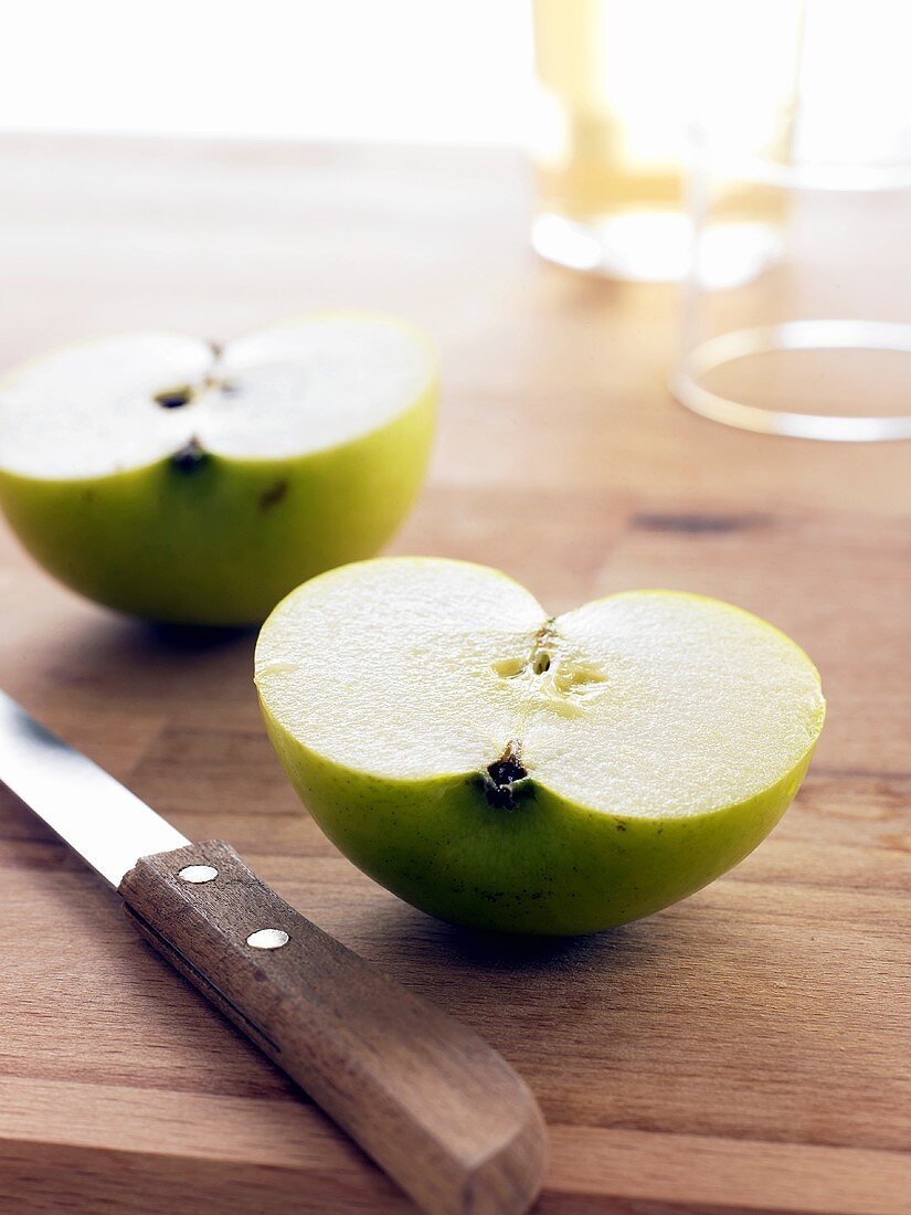 Halbierter Apfel (Sorte: Jonagold) mit Messer