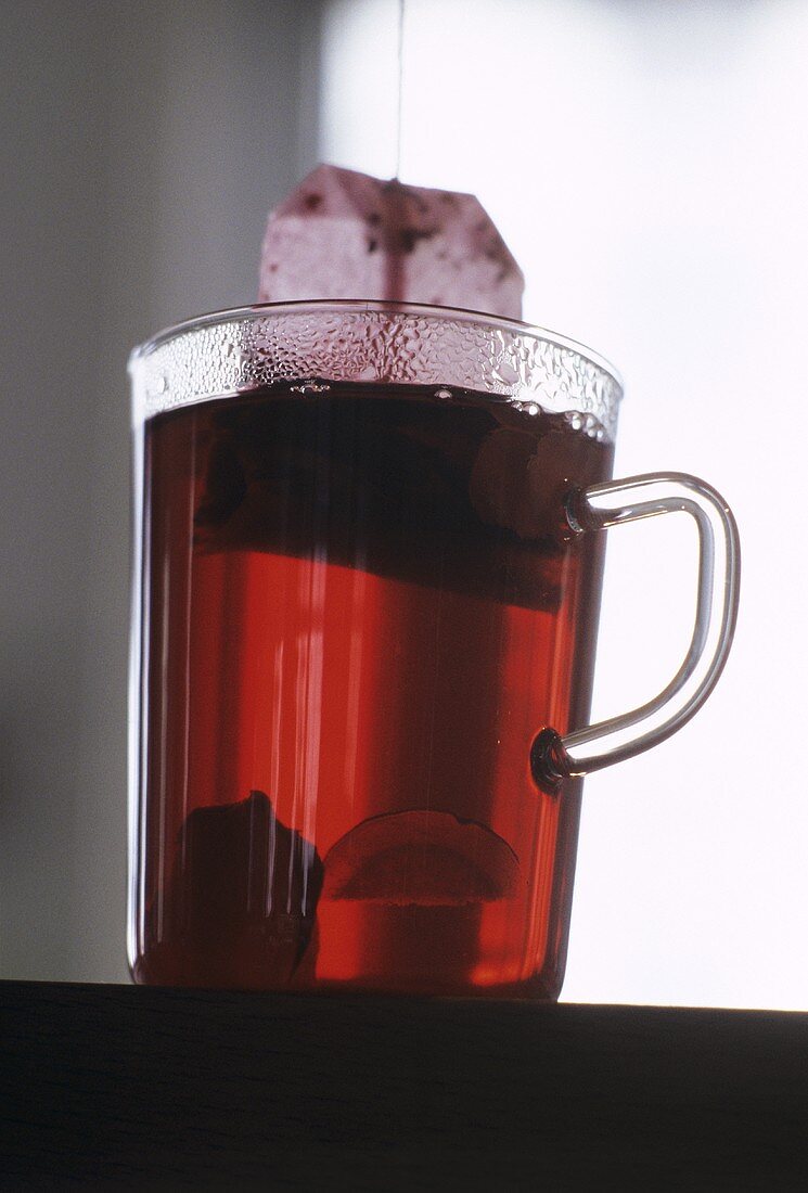 Ein Glas Früchtetee mit Teebeutel