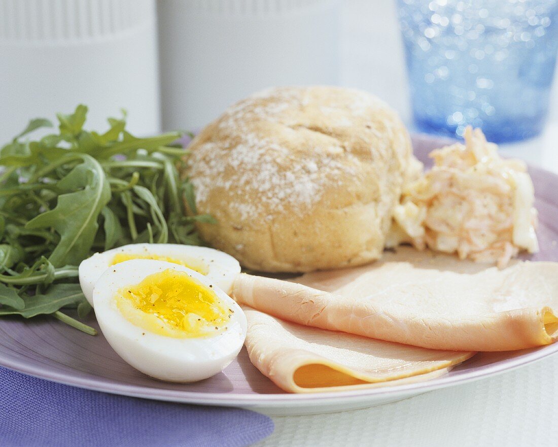 Schinken mit gekochtem Ei, Rucola und Brötchen