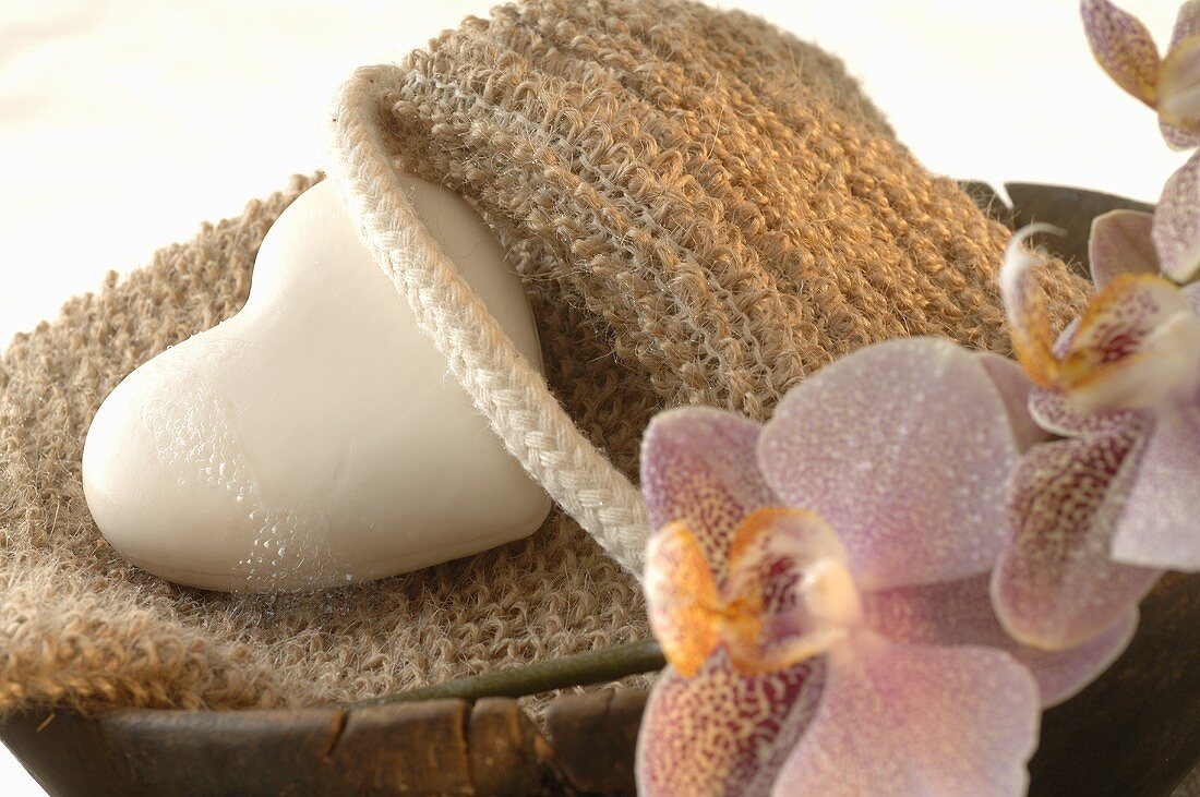 Back strap massager, heart-shaped soap, orchids in wooden bowl