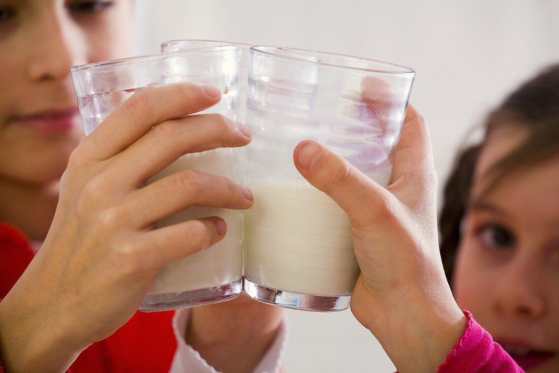 Children clinking glasses of milk together