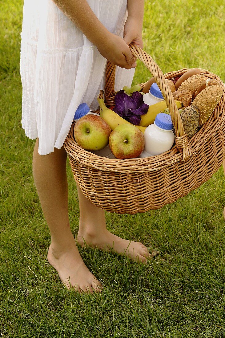Girl holding a basket of groceries