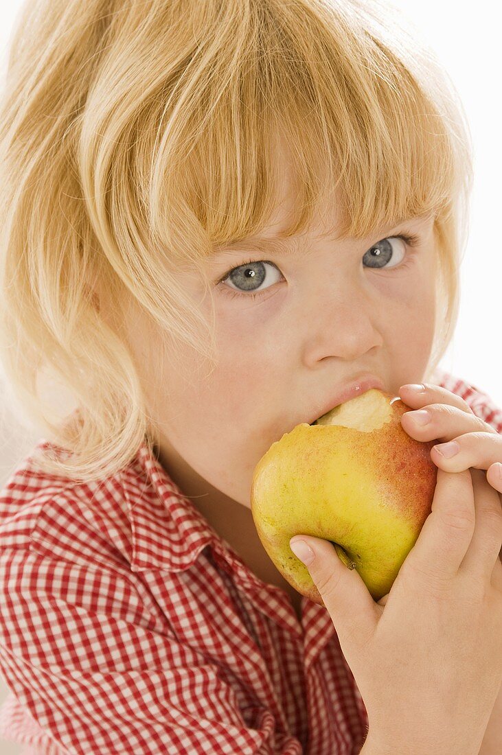 Kleines Mädchen isst einen Bio-Apfel