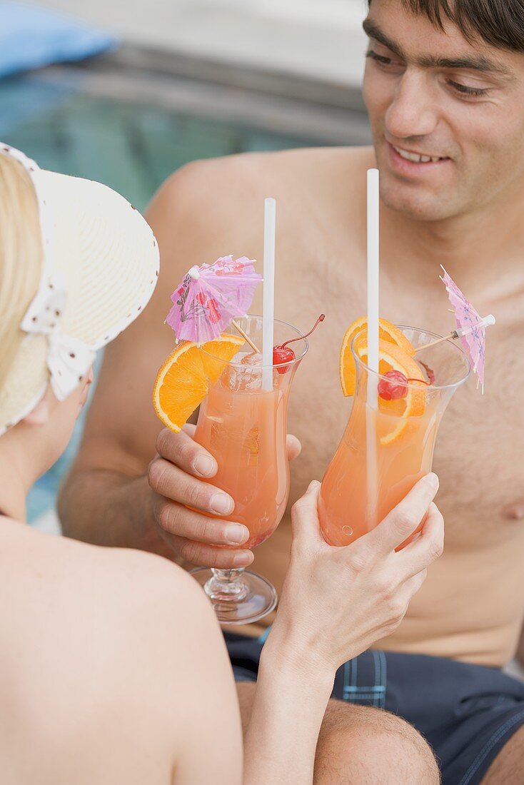 Frau und Mann mit Planters Punch am Pool