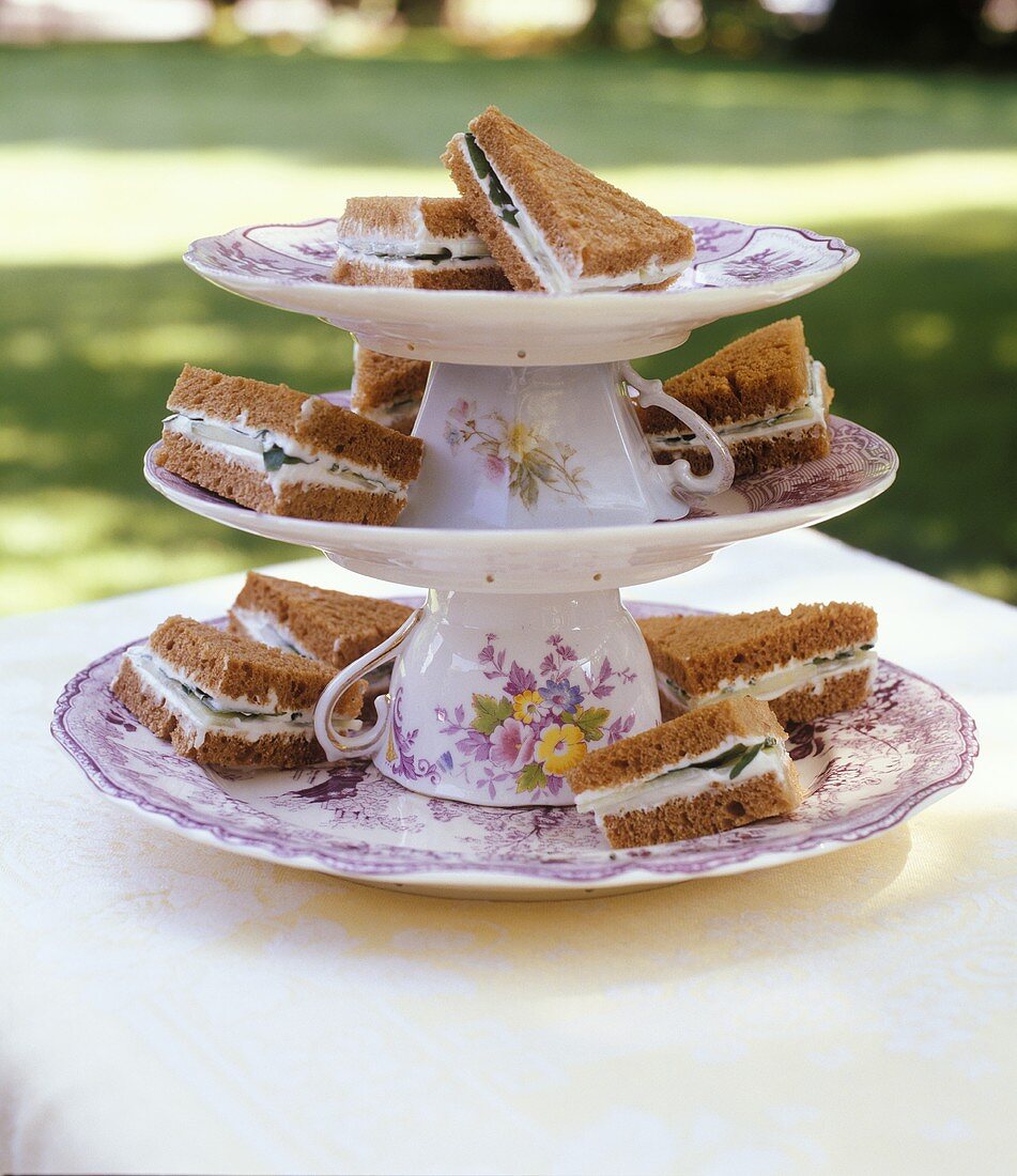 Sandwiches on tiered stand made with upturned cups