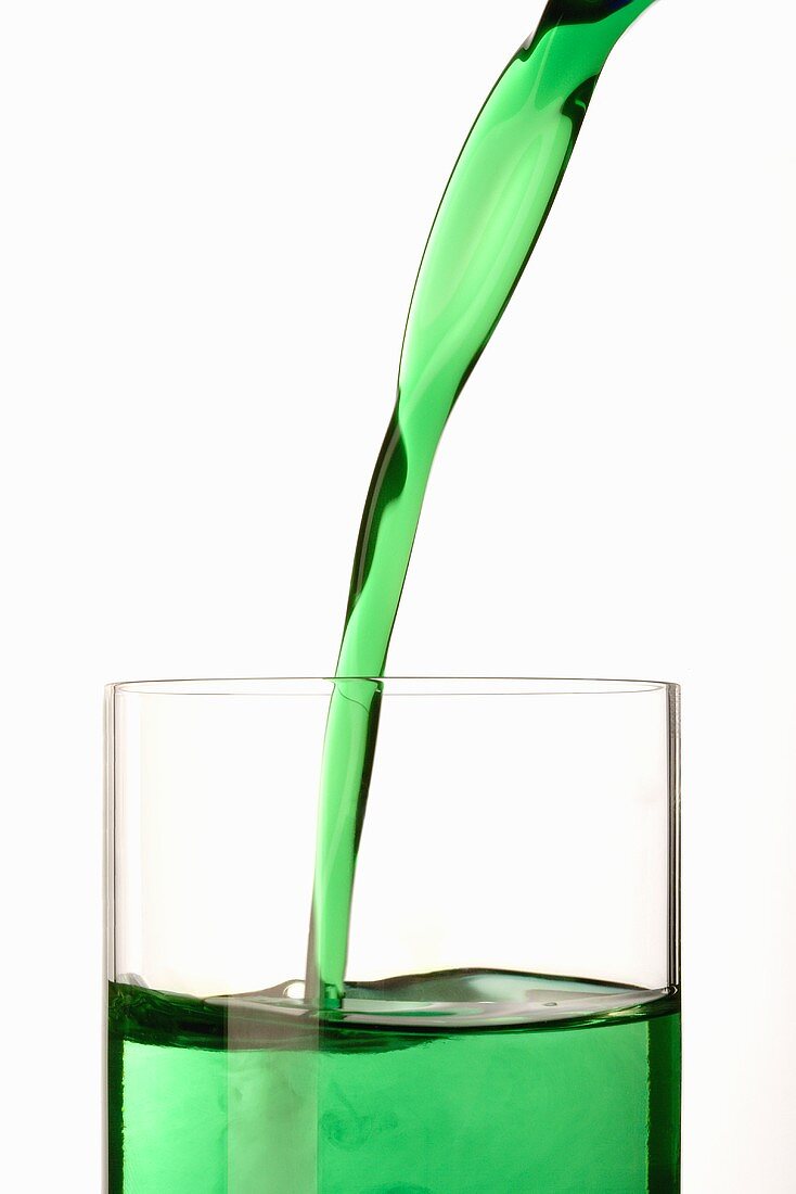 Pouring mint syrup into a glass