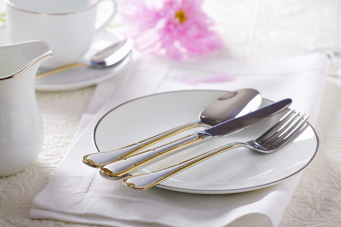 Gold-rimmed plate with cutlery