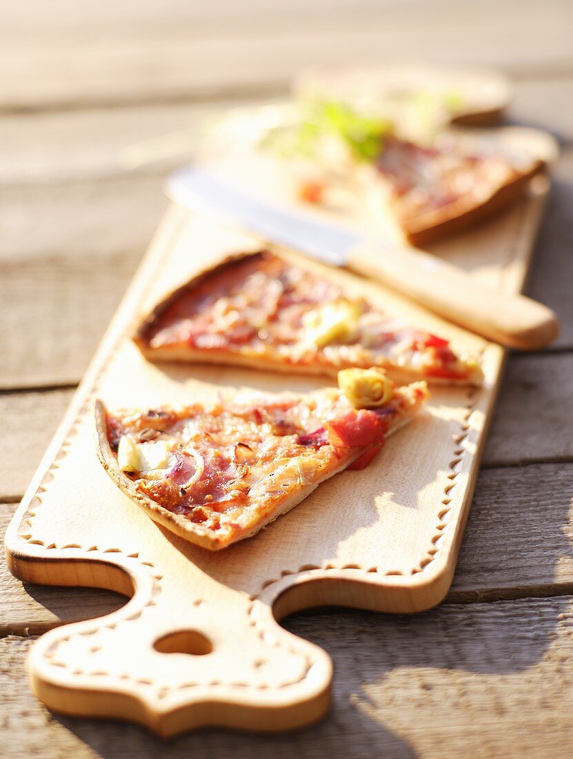 Slices of pizza on chopping board