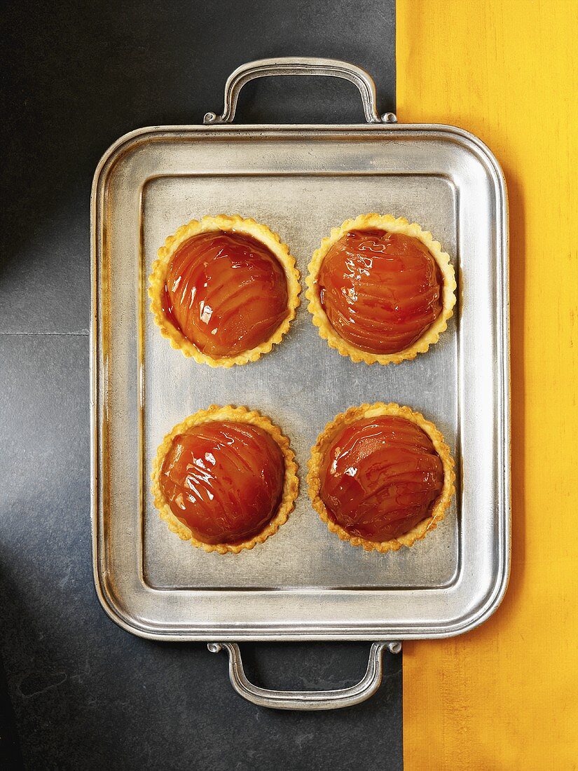 Four quince tarts on silver tray (from above)