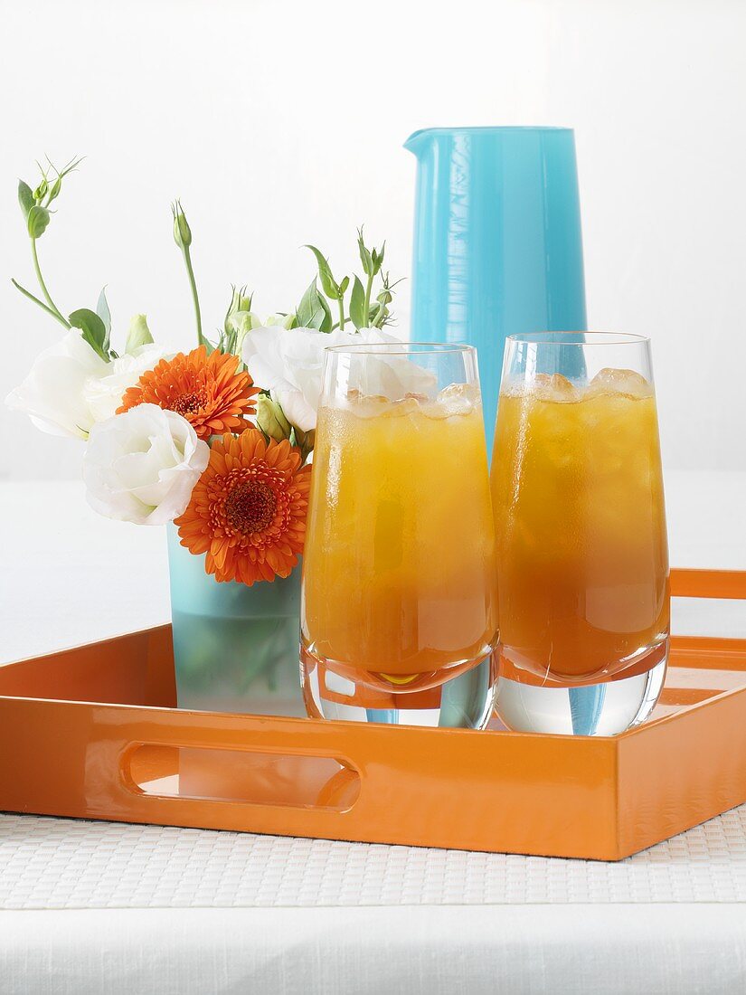 Apricot juice and small posy of flowers on tray