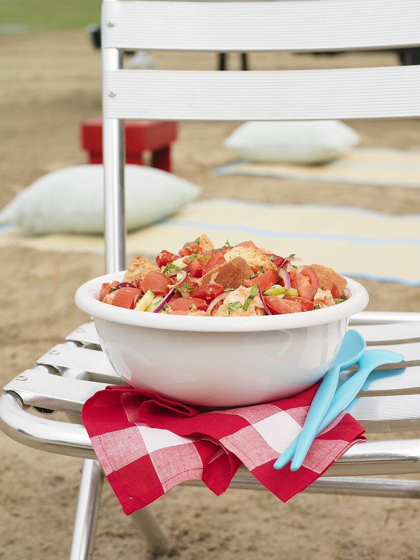 Tomaten-Brot-Salat auf einem Stuhl am Strand