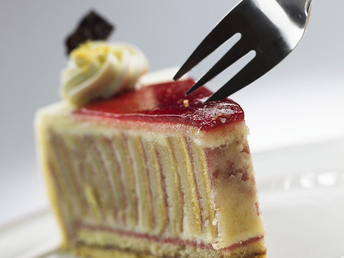 A piece of raspberry marzipan cake with cake fork