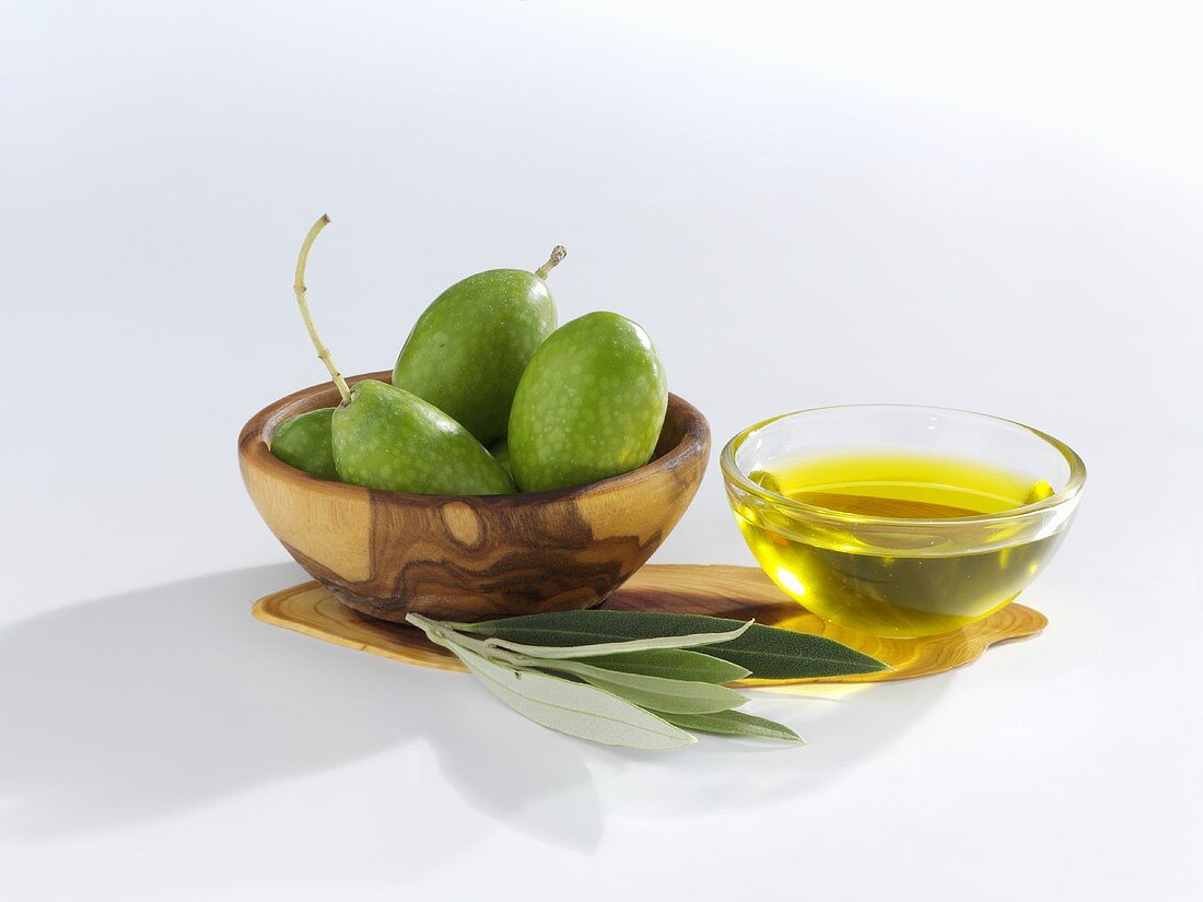 Grüne Oliven, Olivenblätter und Olivenöl