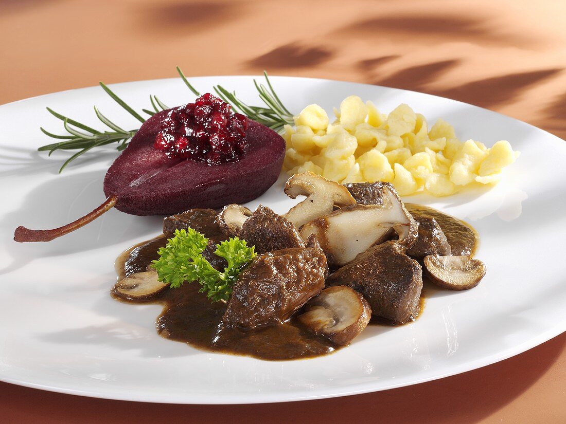 Venison ragout with mushrooms and red wine pear