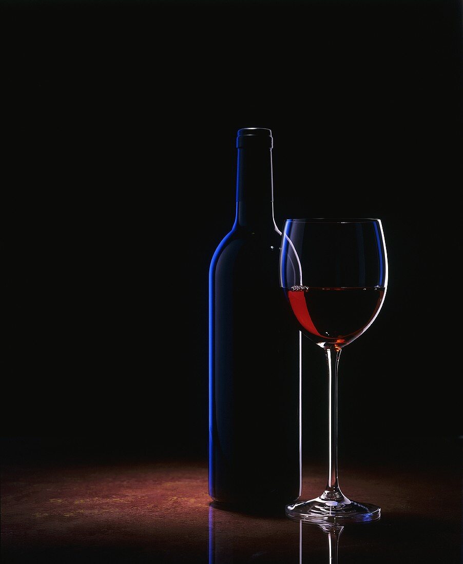 Ein Glas Rotwein und eine Weinflasche