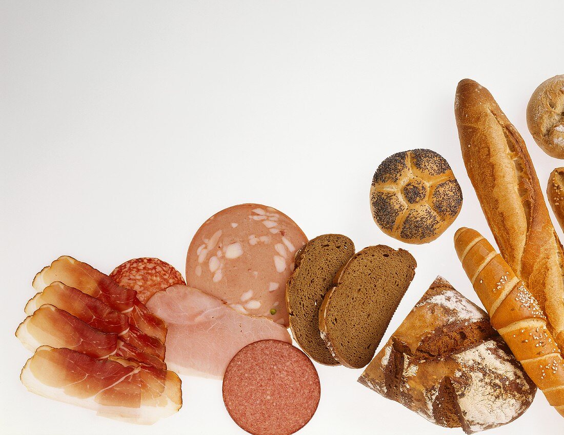 Various types of bread, sliced meats and ham