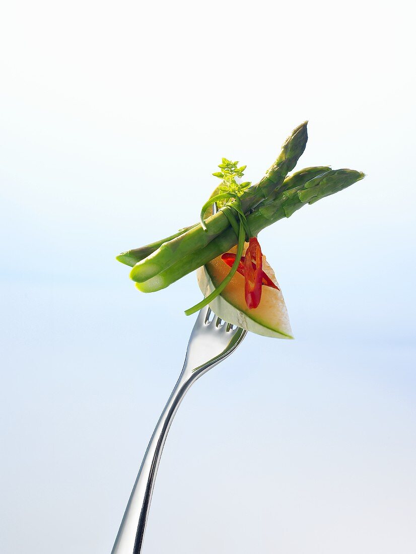 Charentais melon, chilli and green asparagus on a fork
