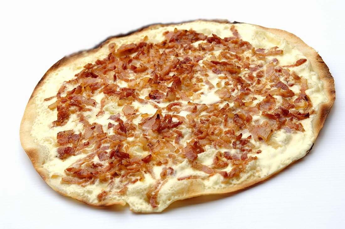 Tarte flambée topped with bacon and onions