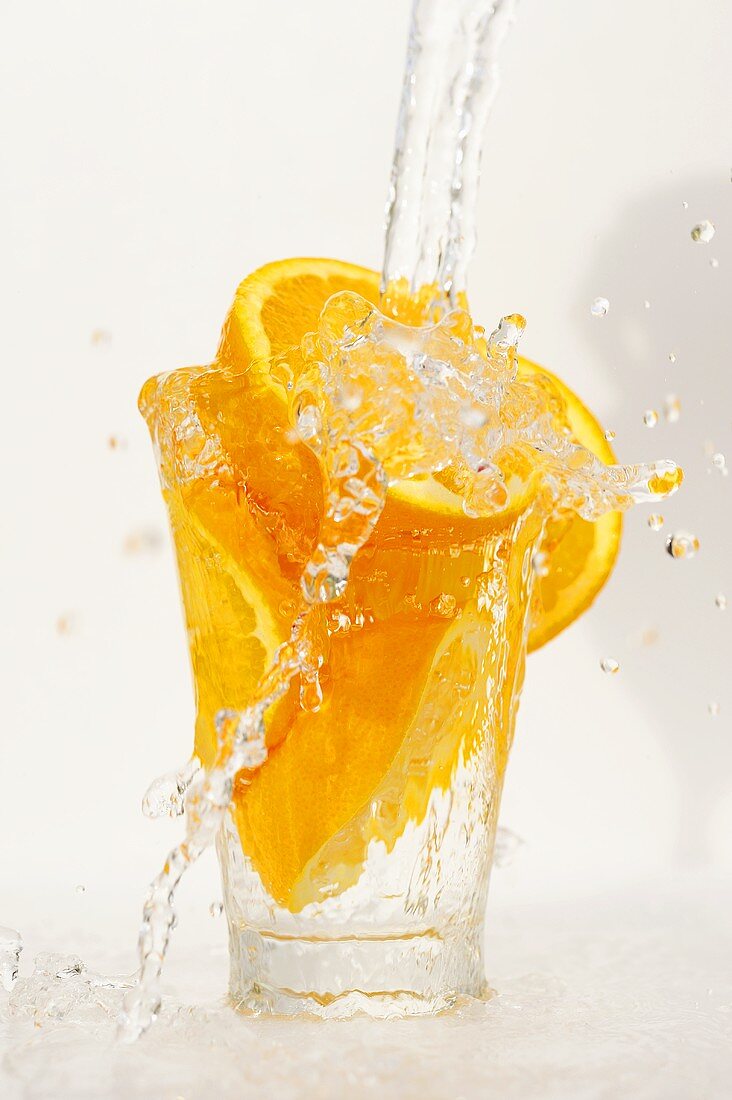 Orangen in einem Glas mit Wasser