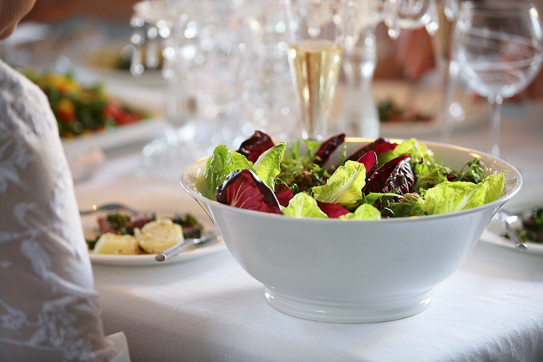 A bowl of salad on a decoratively laid table