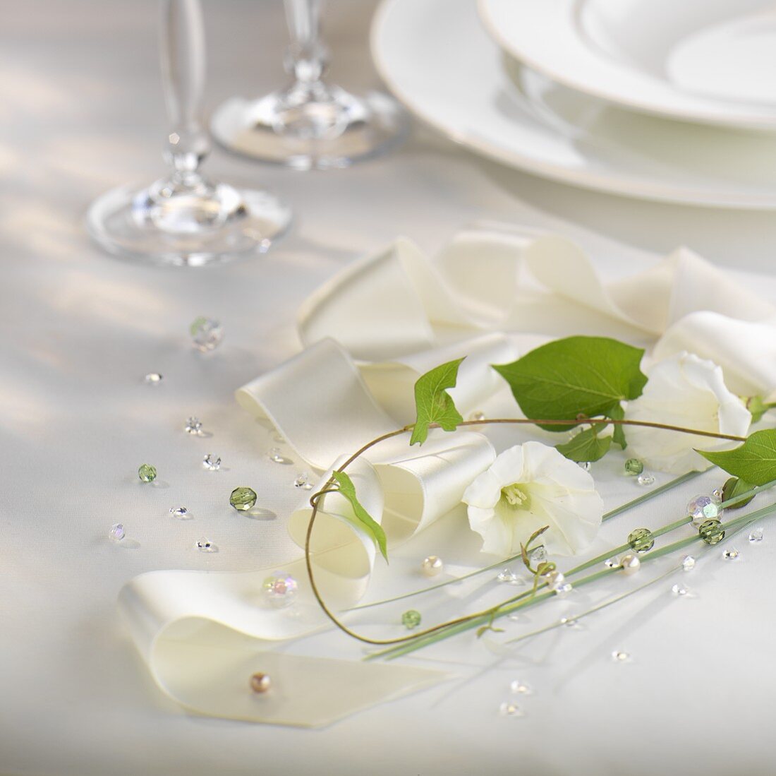 Festliche Tischdeko mit weisser Schleife und Blumen