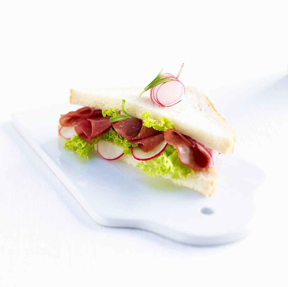 A ham, lettuce and radish sandwich
