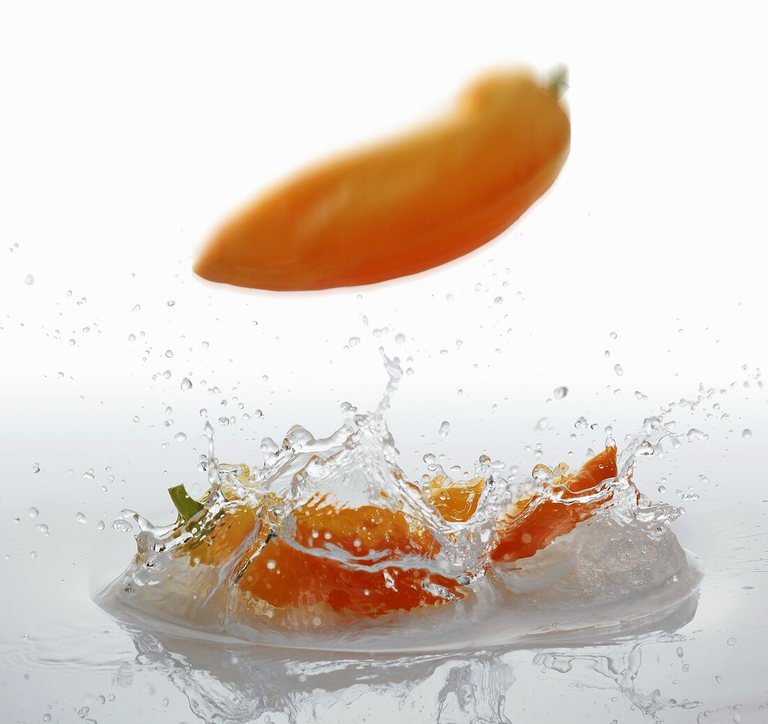 Pointed peppers falling into water