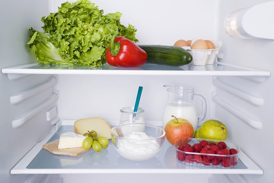 An open fridge with various types of fresh produce