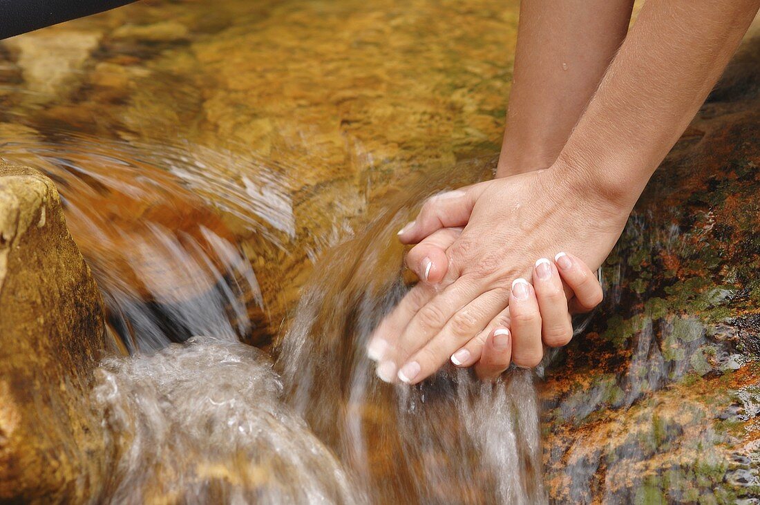 A woman holding her hands under running water