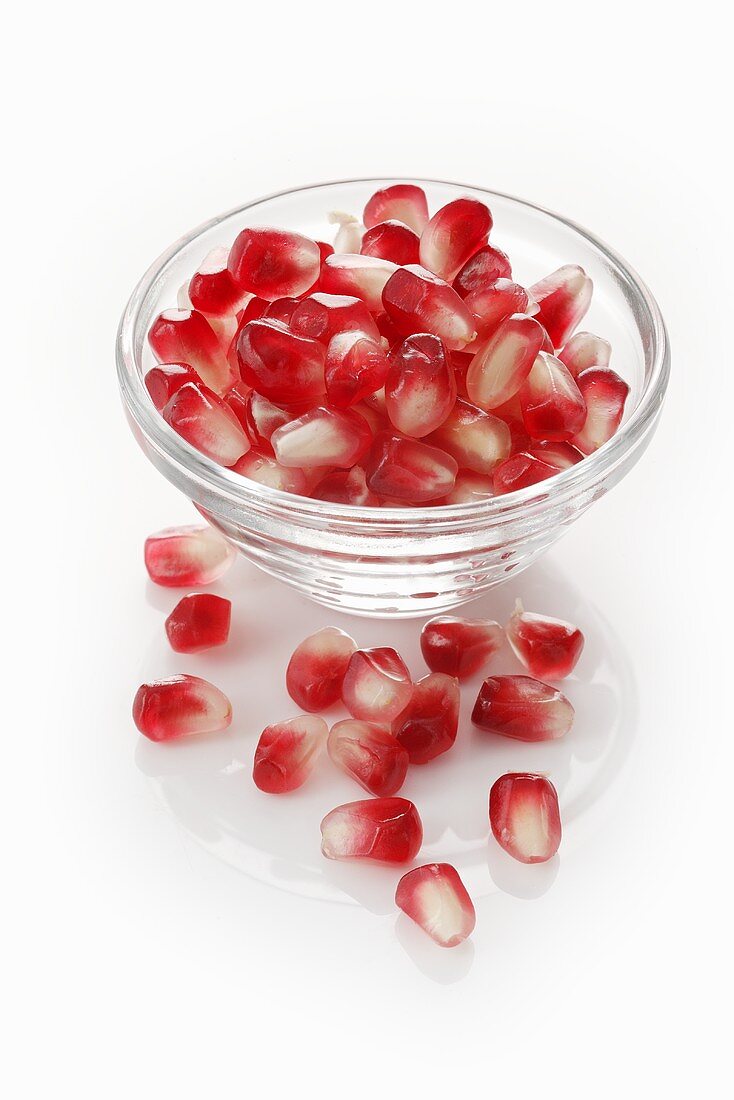 Pomegranate seed in a glass bowl and next to it
