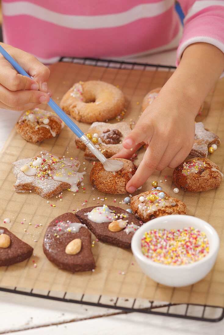 A girl decorating biscuits with icing sugar