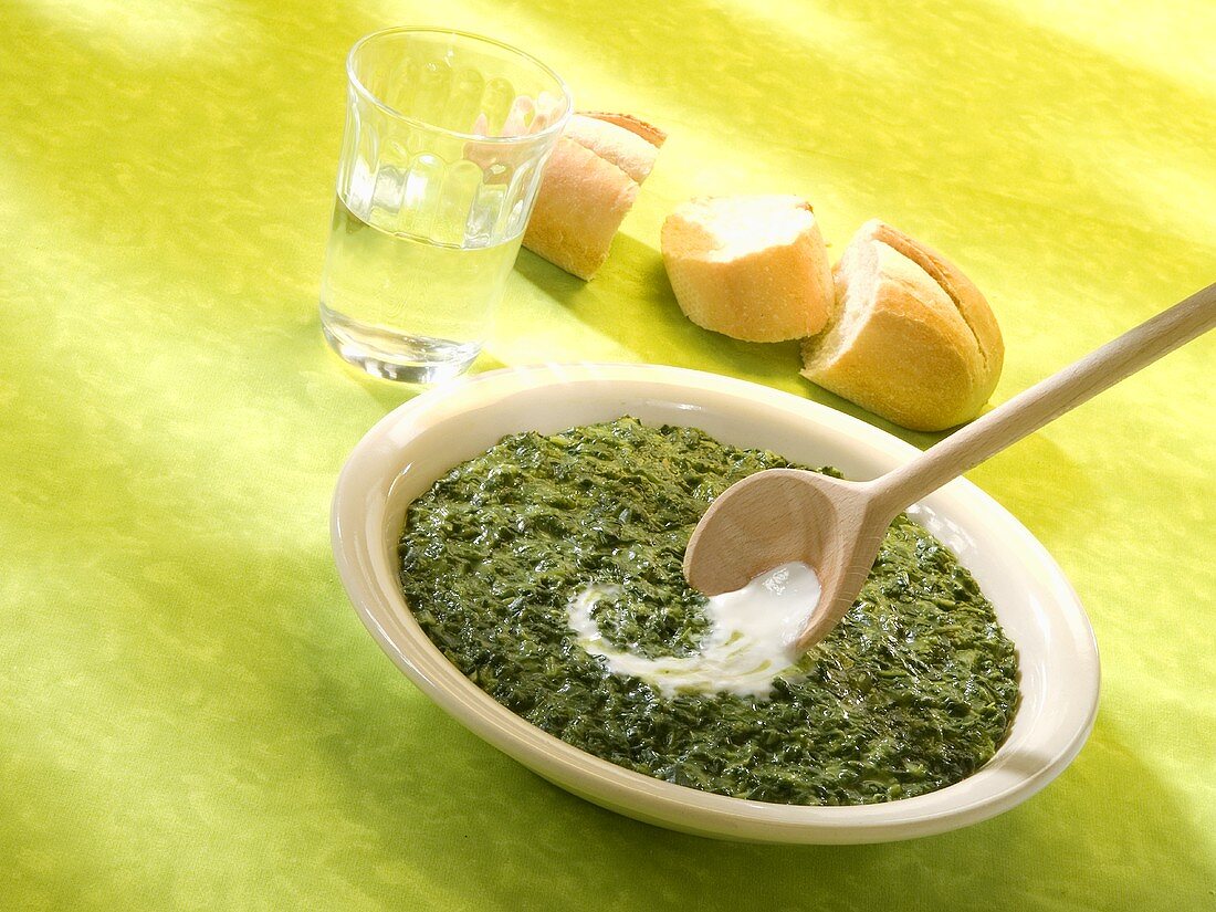 Spinach with sour cream, baguette and a glass of water