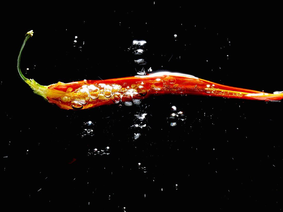A sliced open chilli pepper in water