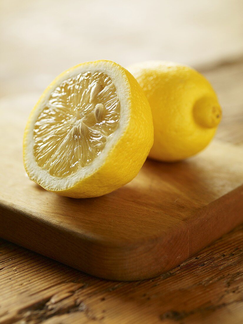 Whole and Half of a Lemon on a Cutting Board