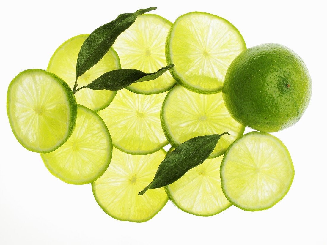 A whole lime, lime slice and lime leaves